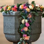Pia batismal decorada com flores no interior de uma capela cristã