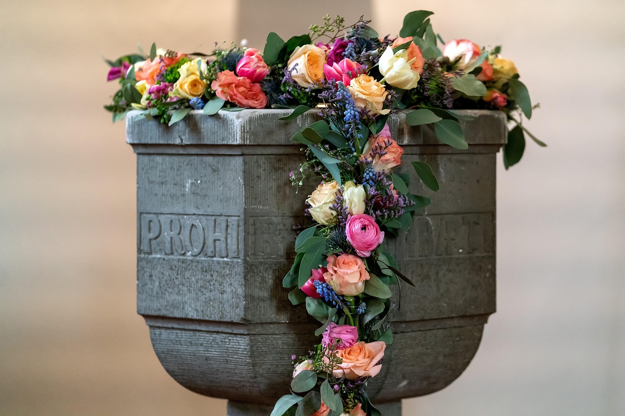 Pia batismal decorada com flores no interior de uma capela cristã